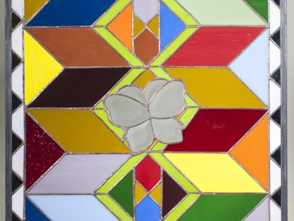 Stained glass with chevron colored panels and a white butterfly in the center