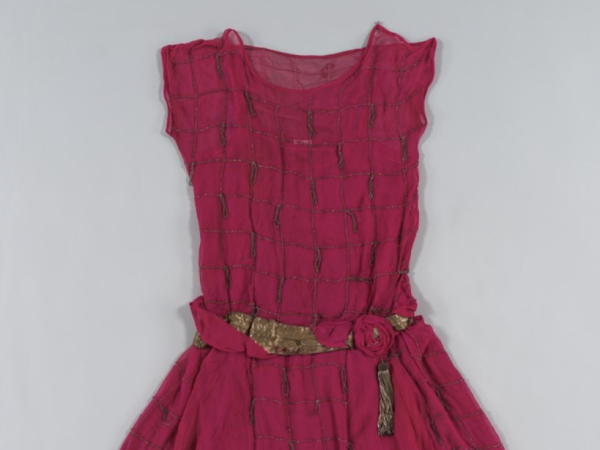 A photo of a pink beaded dress with gold lamé belt.