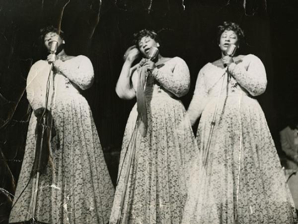 Three images of Ella Fitzgerald, side by side. Her eyes are closed as she sings into the microphone she is holding in front of her. 