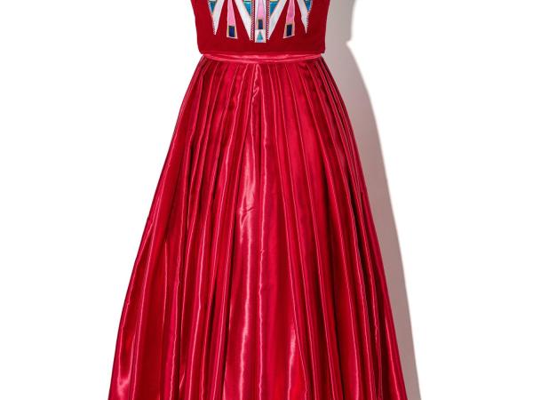 Red prom dress with an applique indigenous design at the top. The dress form also includes a beaded choker necklace.