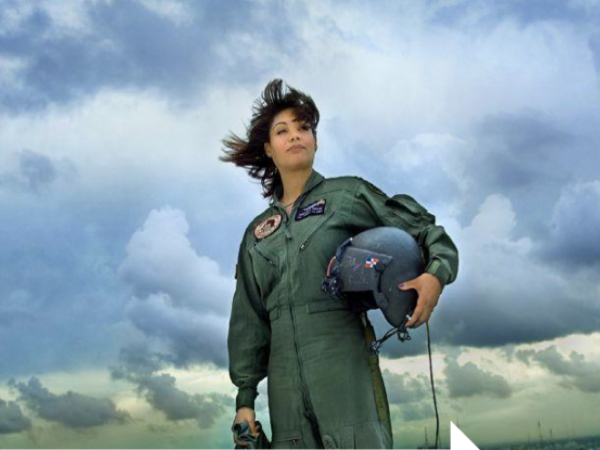 Major Marisol A. Chalas in her flight uniform with a stormy sky behind her.