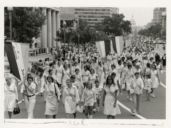 group of women dressed in white marching in parade