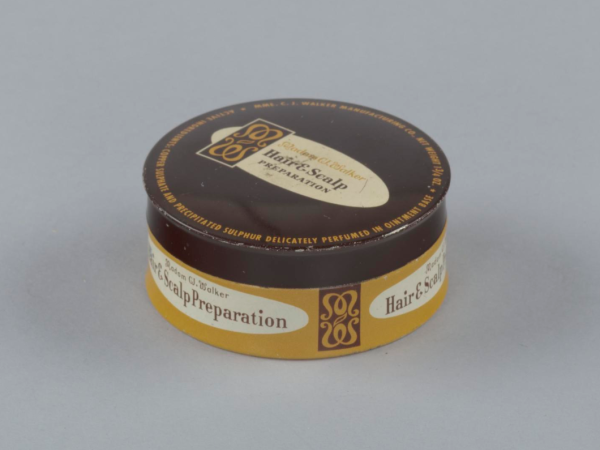 The lid has a brown background with yellow text and at its center is a white oval formatted with the Madam CJ Walker logo on its left and the product name [Madam CJWalker/Hair &amp;amp; Scalp/Preparation] written in brown text. 