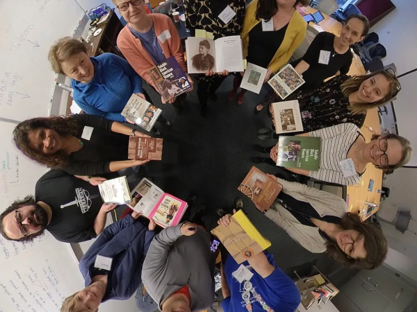 People standing in a circle with books in their hands 