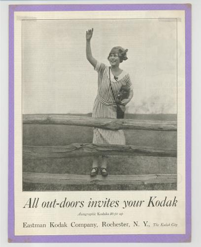 Advertisement with a black and white photograph of a young woman wearing a striped dress. She is holding a camera in her left hand as she stands on the bottom beam of wood fence and waves her right hand.