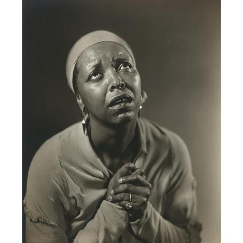 Ethel Waters holds her hands and stares sadly upward.