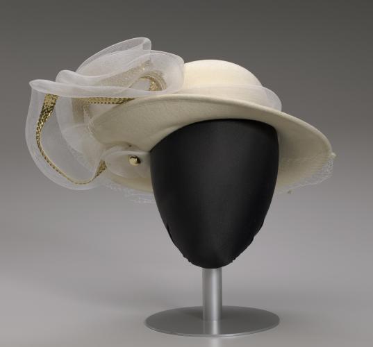 A cream-colored hat on a black mannequin head.