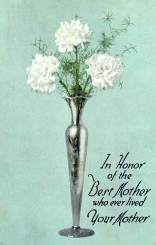 Front side of a postcard with three white carnations in a tall glass vase centered on a light green background. The text “In Honor of the Best Mother who ever lived Your Mother” is in the lower right corner. 