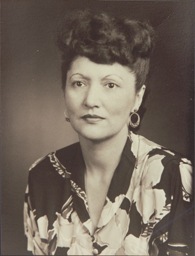 Black and white photograph of Elizabeth Peratrovich wearing a floral shirt and hoop earrings