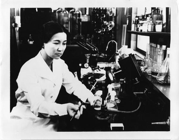 Woman sits at a microscope