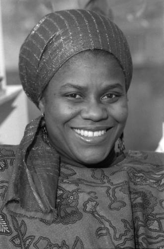 Black and white photo of Bernice Johnson Reagon similing. She wears a sparkly headscarf.